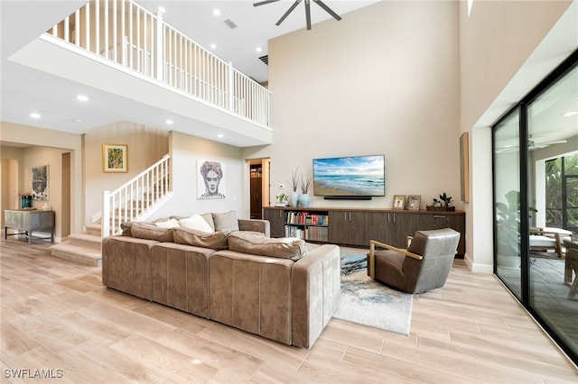 living room with a towering ceiling and light hardwood / wood-style floors