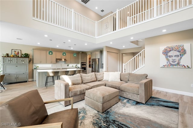 living room featuring a high ceiling and light wood-type flooring