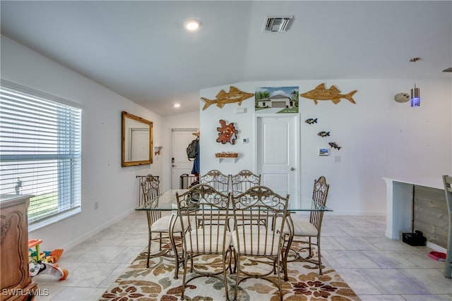 tiled dining area with vaulted ceiling