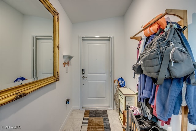 mudroom with vaulted ceiling and light tile patterned flooring