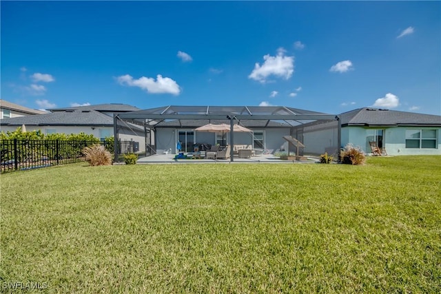 rear view of property with a lanai, a patio area, a lawn, and fence