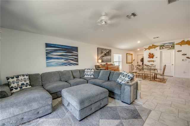 tiled living room with ceiling fan and lofted ceiling