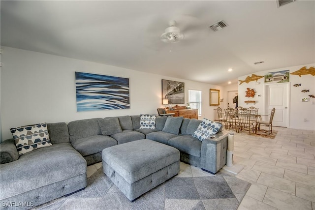 living area featuring vaulted ceiling, ceiling fan, and visible vents