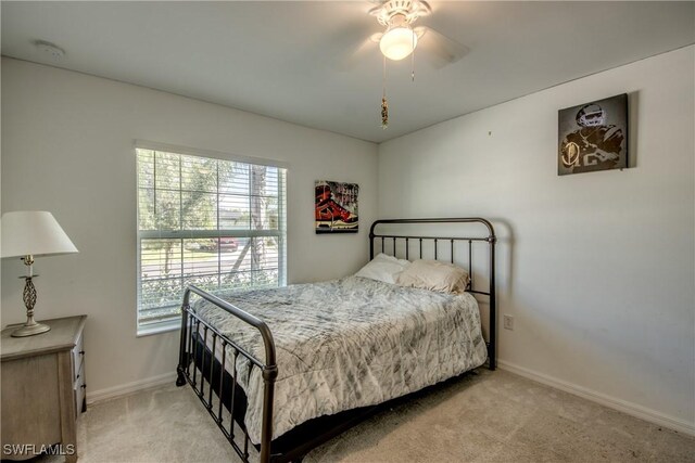 bedroom featuring multiple windows, ceiling fan, and light colored carpet