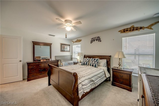 bedroom with light carpet, ceiling fan, and visible vents