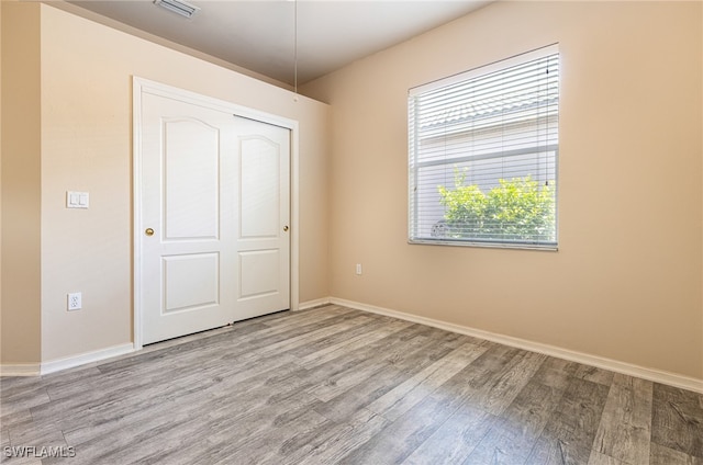 unfurnished bedroom with a closet and wood-type flooring