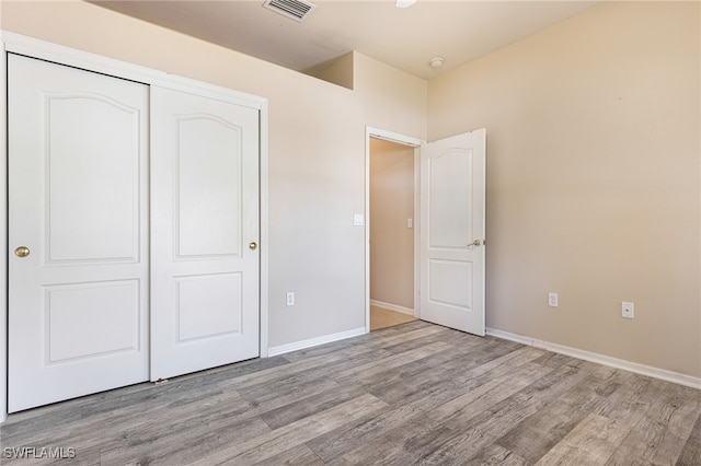 unfurnished bedroom featuring hardwood / wood-style floors and a closet