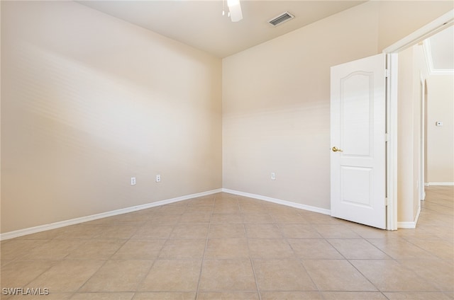 tiled spare room featuring ceiling fan