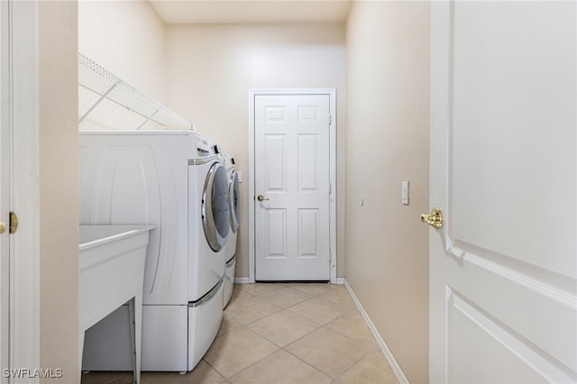 laundry room with light tile patterned floors and washing machine and clothes dryer