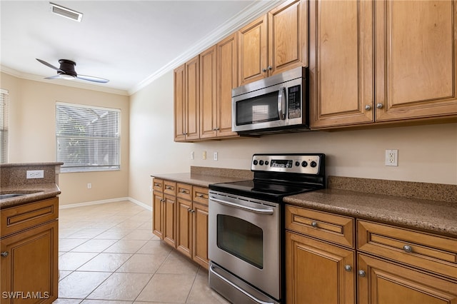 kitchen featuring ceiling fan, appliances with stainless steel finishes, light tile patterned flooring, and crown molding