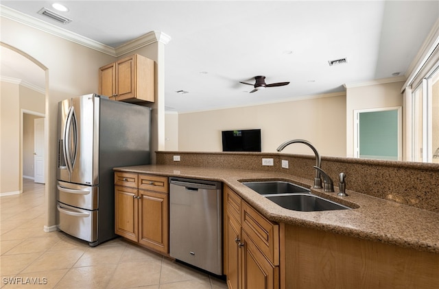 kitchen featuring ceiling fan, appliances with stainless steel finishes, light tile patterned flooring, ornamental molding, and sink