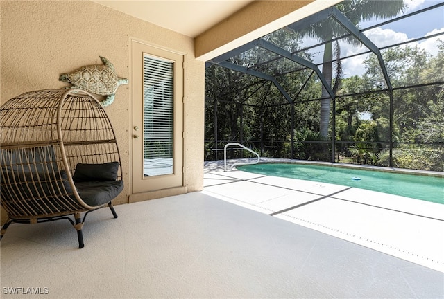 view of pool featuring glass enclosure and a patio