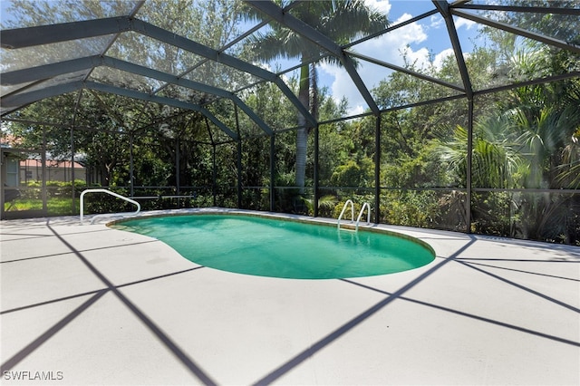 view of swimming pool with glass enclosure and a patio area