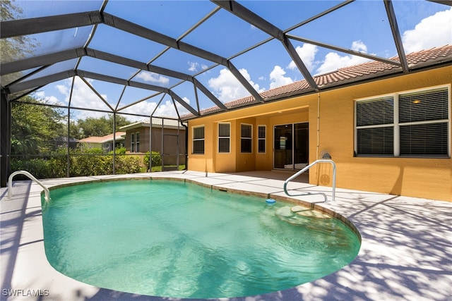 view of pool with glass enclosure and a patio