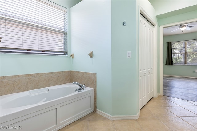 bathroom featuring ceiling fan, a tub to relax in, and tile patterned floors