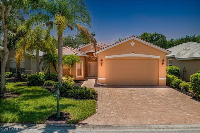 mediterranean / spanish house featuring a front yard and a garage