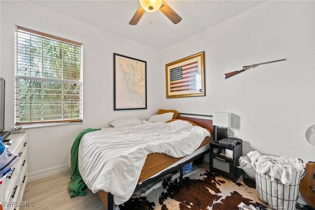 bedroom with light wood-type flooring, ceiling fan, and multiple windows