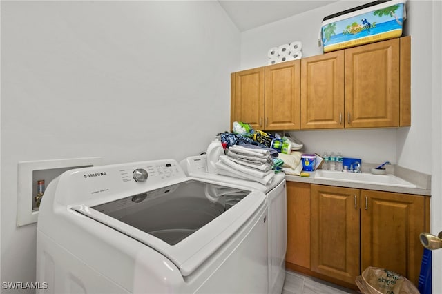 laundry room with sink, cabinets, separate washer and dryer, and light tile patterned floors