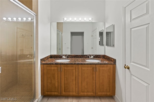 bathroom with double sink vanity and a shower with door