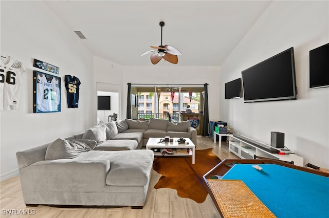 living room featuring ceiling fan, vaulted ceiling, and light wood-type flooring