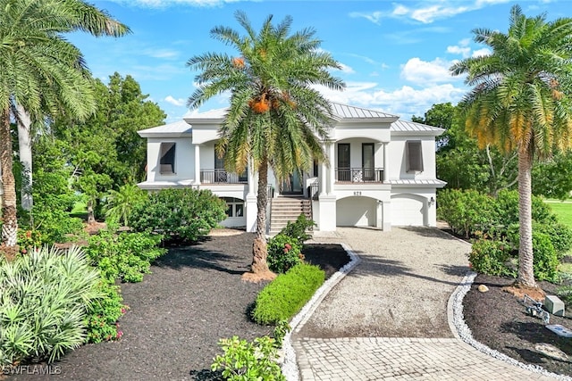 829 Pyrula Ave, Sanibel, FL 33957 - view of front of property with stucco siding, metal roof, decorative driveway, a standing seam roof, and stairs