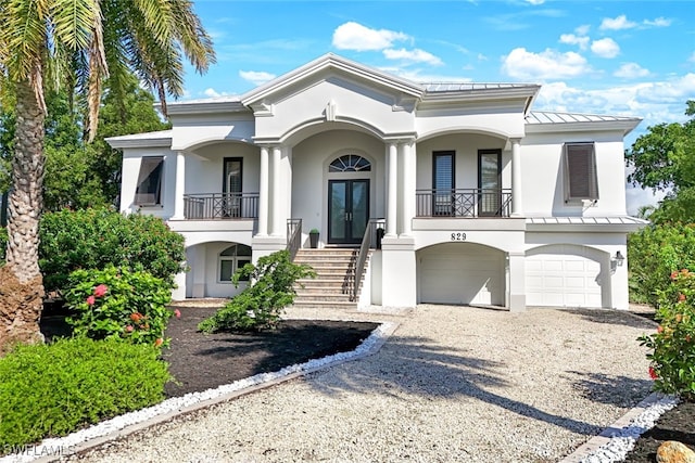 829 Pyrula Ave, Sanibel, FL 33957 - view of front facade with a standing seam roof, french doors, gravel driveway, stairs, and stucco siding