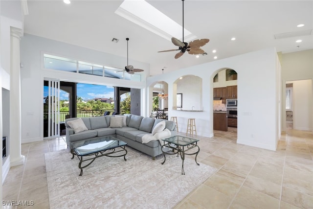 living room featuring a high ceiling, light tile patterned flooring, and ceiling fan