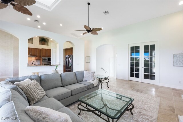 living room featuring french doors, ceiling fan, and a high ceiling