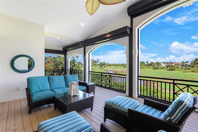 wooden terrace with ceiling fan and an outdoor living space