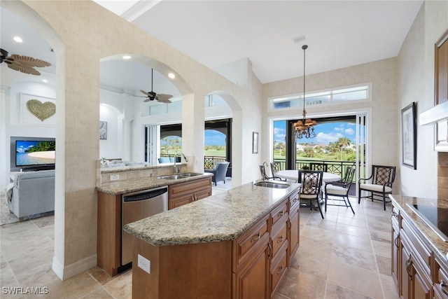 kitchen with a kitchen island, dishwasher, sink, light stone countertops, and pendant lighting