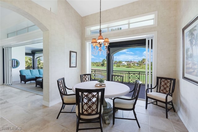 dining area featuring a wealth of natural light, a chandelier, and a high ceiling