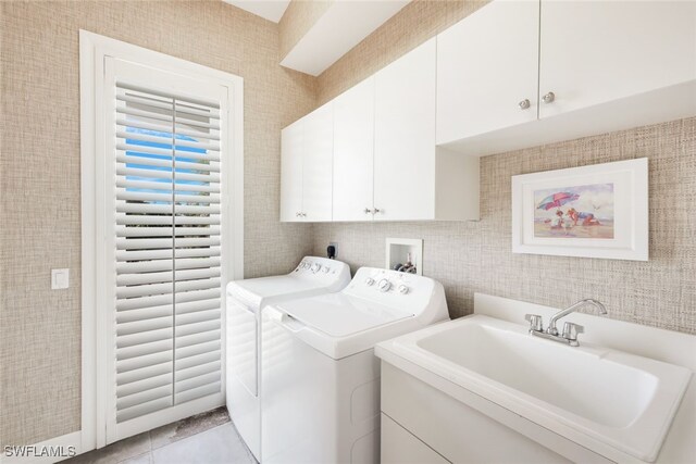 laundry room with cabinets, sink, washing machine and dryer, and light tile patterned floors