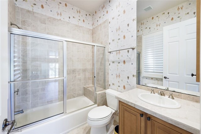 full bathroom featuring toilet, enclosed tub / shower combo, and vanity