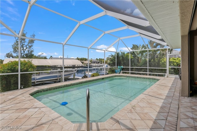 view of swimming pool with a water view, a lanai, and a patio area