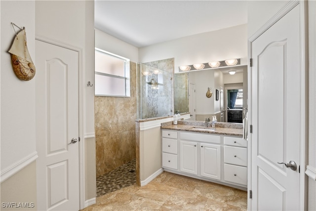 bathroom featuring a tile shower and vanity