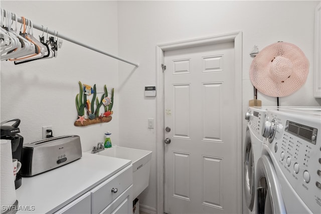 laundry room with washing machine and clothes dryer and cabinets