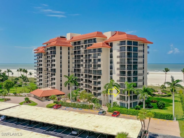 view of building exterior with a water view and a beach view