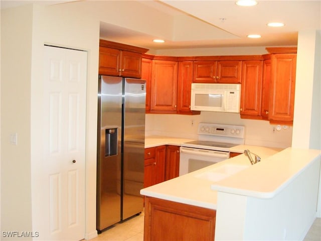 1001 Arbor Lake Dr Unit 203, Naples, FL 34110 - kitchen with white appliances, a peninsula, light countertops, a sink, and recessed lighting