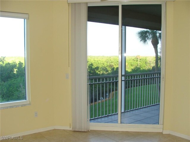 doorway to outside with light tile patterned floors and a healthy amount of sunlight