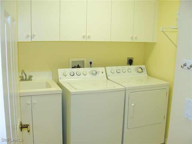 clothes washing area featuring sink, independent washer and dryer, and cabinets