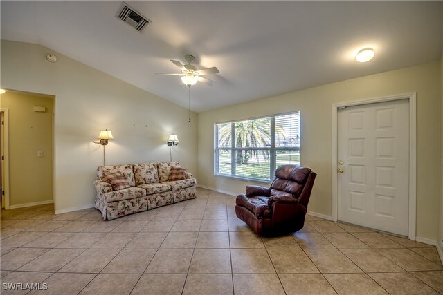 tiled living room featuring ceiling fan and vaulted ceiling