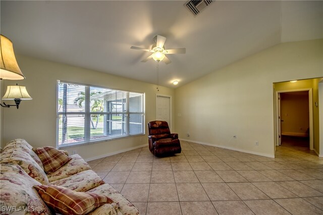 living area featuring lofted ceiling, light tile patterned floors, and ceiling fan