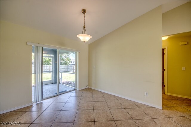 empty room featuring lofted ceiling and light tile patterned floors