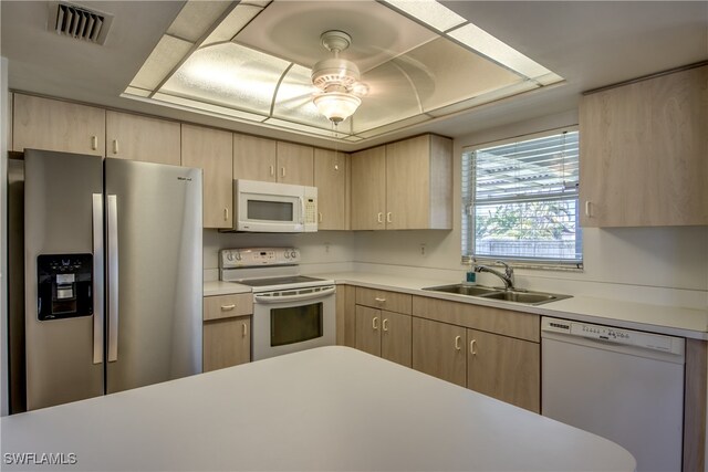 kitchen with ceiling fan, white appliances, sink, and light brown cabinets