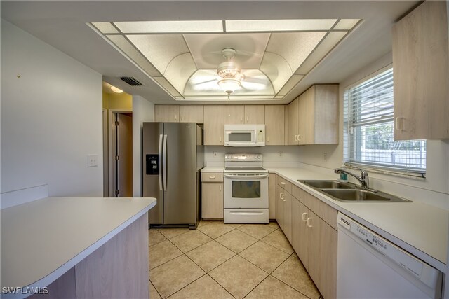 kitchen with light brown cabinetry, white appliances, light tile patterned floors, ceiling fan, and sink