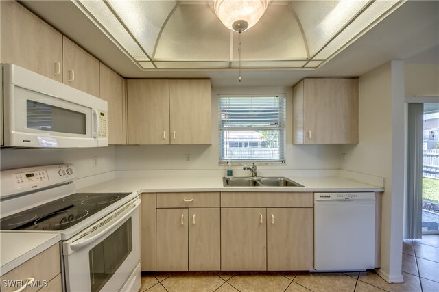 kitchen with sink, light brown cabinets, white appliances, and light tile patterned floors