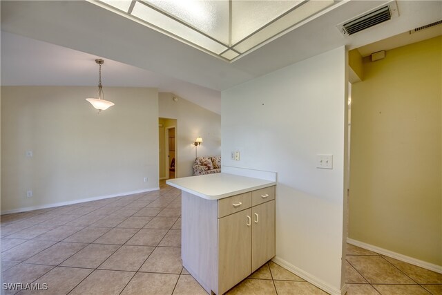 kitchen with kitchen peninsula, light tile patterned floors, lofted ceiling, and pendant lighting