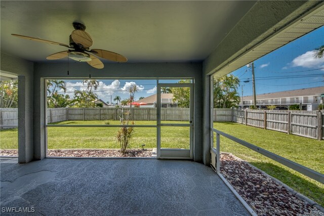 unfurnished sunroom featuring ceiling fan