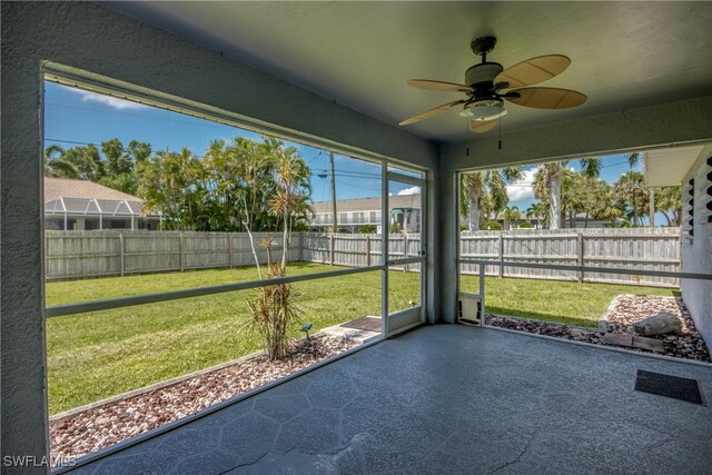 unfurnished sunroom featuring ceiling fan