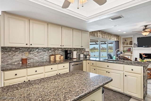 kitchen with ceiling fan, dark stone counters, tasteful backsplash, dishwasher, and sink